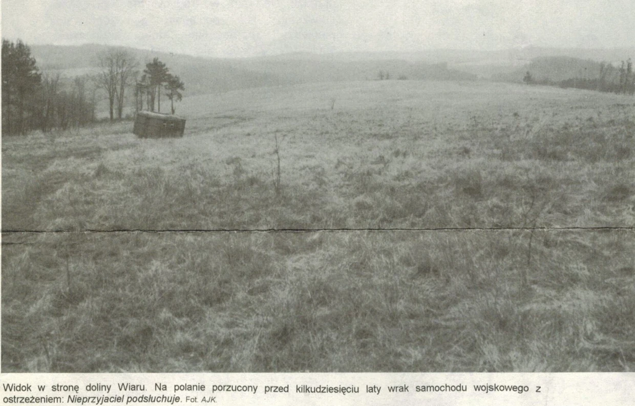 Widok w stronę doliny Wiaru. Na polanie porzucony przed kilkudziesięciu laty wrak samochodu wojskowego z ostrzeżeniem: „Nieprzyjaciel podsłuchuje”. Fot. Janusz Korbel