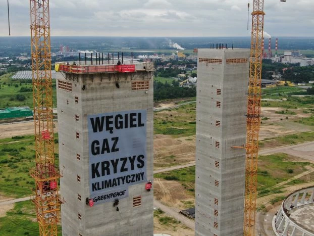 Aktywiści wywiesili olbrzymi baner z hasłem „Węgiel, gaz, kryzys klimatyczny” na ponad stumetrowej betonowej wieży na placu budowy elektrowni Ostrołęka C. Fot. Dominik Werner / Greenpeace Polska