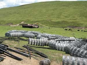 
Grodzenie tybetańskich pastwisk, co utrudnia przemieszczanie się stad, wypasanych przez pasterzy. Odszkodowania dla nich są symboliczne. Na zdjęciu zwoje drutu kolczastego pozostawione na łące dla koczowników, Kham, 2009 r. Fot. International Campaign for Tibet

