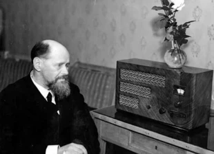 Kazimierz Przerwa-Tetmajer podczas słuchania audycji radiowej przy odbiorniku PZT 126Z, rok 1937. Fot. Narodowe Archiwum Cyfrowe