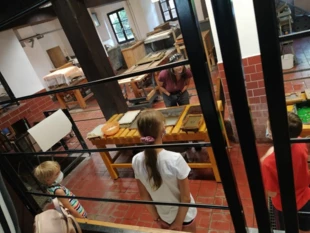 Dzieci ustawione w nienaturalnym dystansie w trakcie warsztatów realizowanych zgodnie z rygorem sanitarnym. Muzeum Papiernictwa w Dusznikach-Zdroju. Fot. Dagmara Stanosz