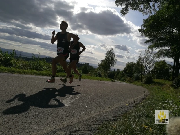 IV Korczyńskim Biegu i Nordic Walking "Do Prządek" - dwóch najlepszych zawodników biegu unoszących się nad ziemią. W tle zamek Kamieniec, znany w "Zemsty" Aleksandra Fredry, a za nim Beskid Niski. Fot. Grzegorz Bożek