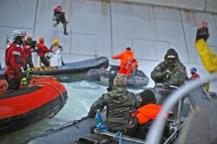 Akcja przeciwko odwiertom Gazpromu w Arktyce. Rosyjski strażnik wybrzeża celuje w aktywistę Greenpeace podczas gdy pięciu protestujących próbuje wspiąć się na platformę wiertniczą Prirazłomnaja, platformę wiertniczą zarządzaną przez państwowego energetycznego giganta – Gazprom. To jeden z przykładów nieuzasadnionego użycia siły przez władze rosyjskie podczas tego pokojowego protestu. © Denis Siniakow / Greenpeace