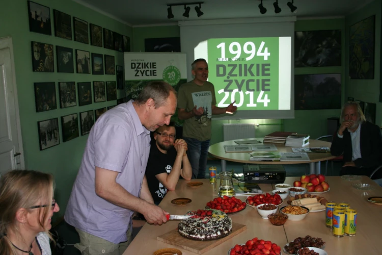 Jubileuszowy tort kroi Jacek Zachara, wieloletni współpracownik Miesięcznika Dzikie Życie. Po prawej...